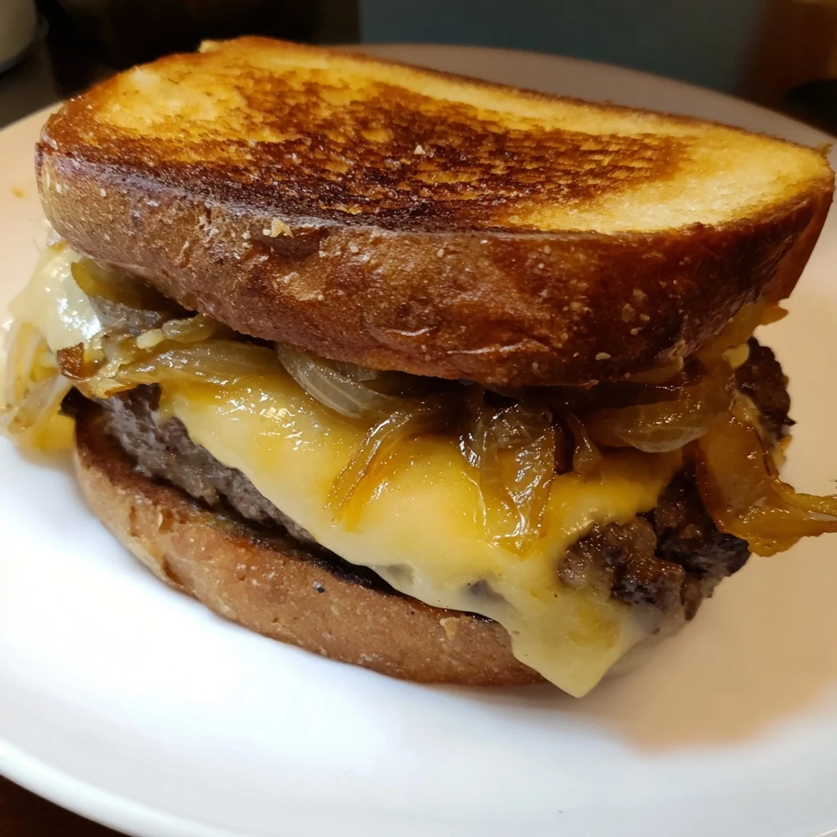Golden-brown cast-iron patty melts with melted Swiss cheese, juicy beef, and sweet caramelized onions.