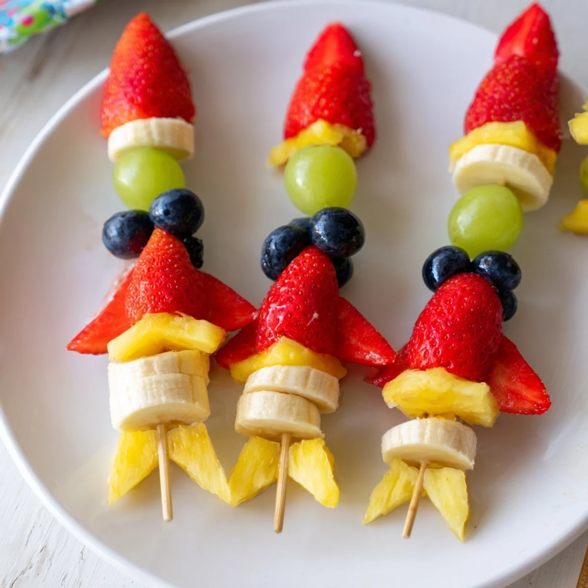 Vibrant Rocket Ship Fruit Skewers with fresh grapes and blueberries: a healthy and delicious party snack.