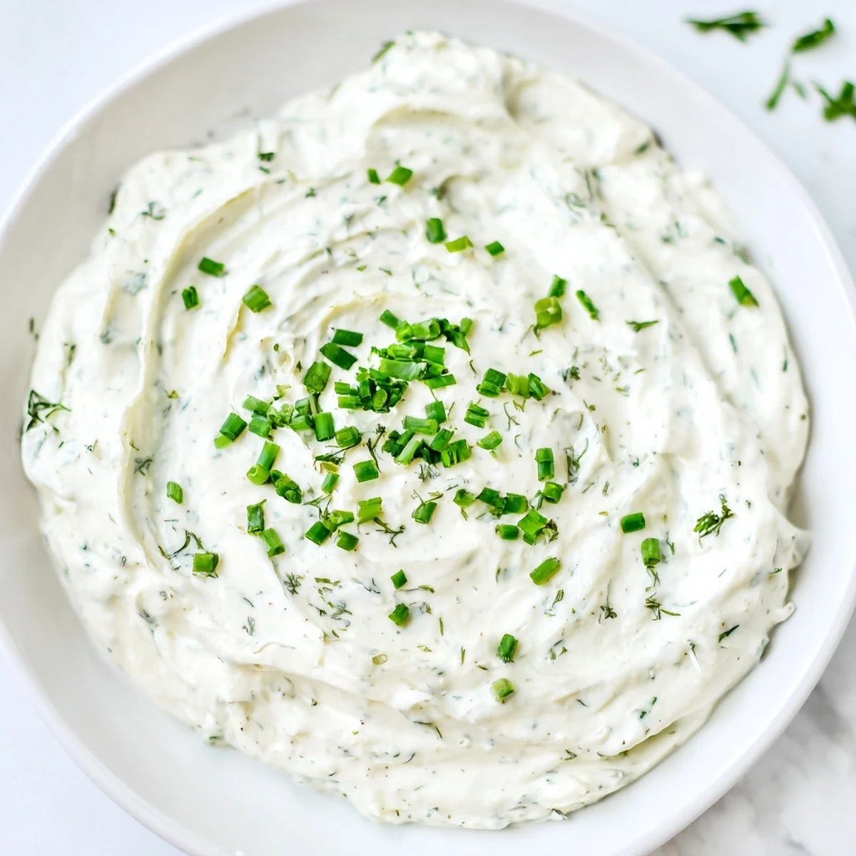 Fresh veggie ranch dip with bright green chives, ready to be enjoyed with crisp carrot sticks.