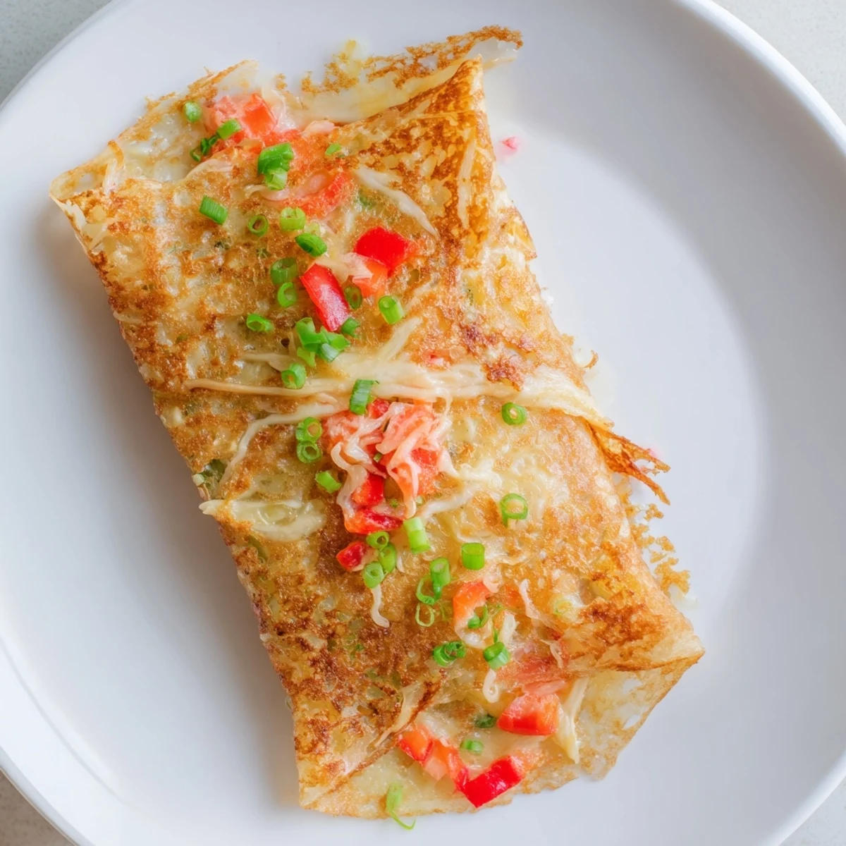 Golden and crispy Rice Paper Egg Cheese Wrap, filled with melted cheese and fresh herbs, ready to enjoy.