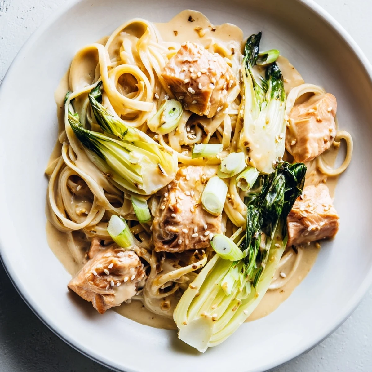 Golden brown miso butter salmon pasta with a vibrant bok choy garnish, a flavorful, tempting plate.
