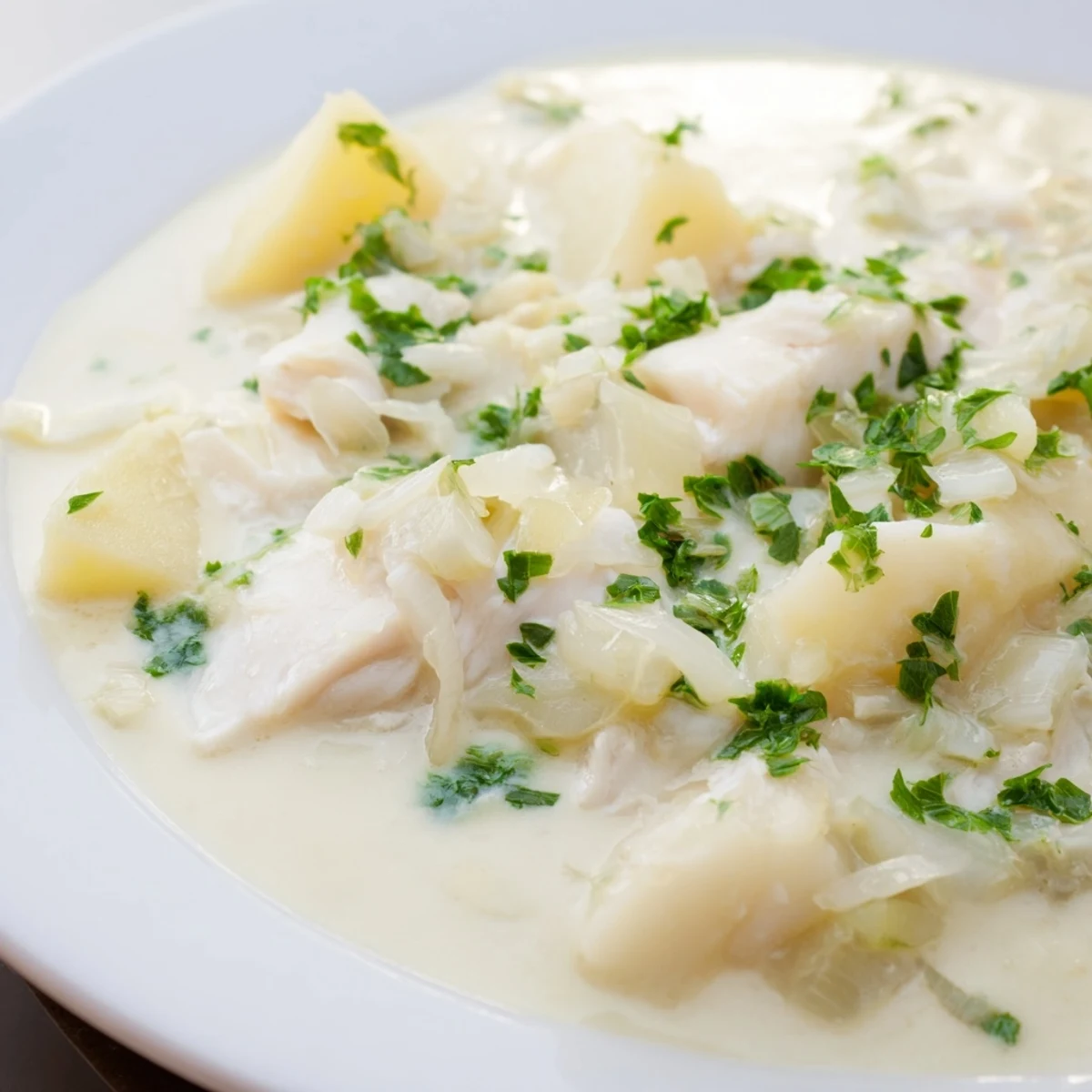 Creamy Icelandic Fish Stew, filled with tender fish and potatoes, and garnished with fresh herbs.