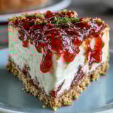 Creamy Easy Guava Swirl Cheesecake with vibrant pink fruit ribbons, served chilled on a dessert plate.