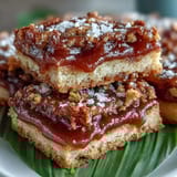 Golden-baked Guava Cake Bars with tender pastry layers and vibrant pink guava paste filling on a wooden board.