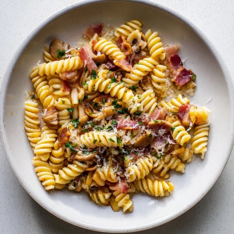 Fusilli with Bacon, Onions, and Mushrooms, a delicious dish with a creamy sauce and crispy bacon.