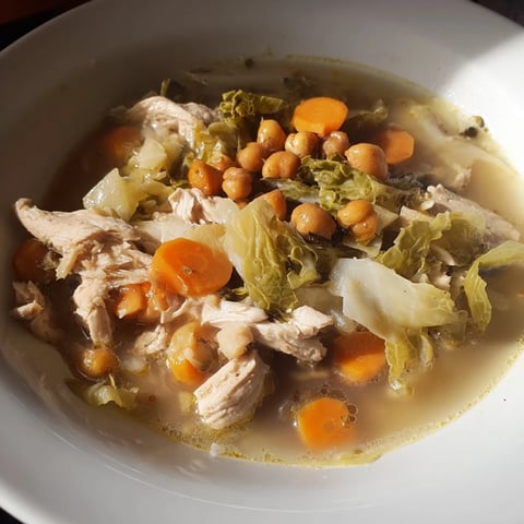 Steaming bowl of Chicken Kale Soup with Crispy Chickpeas, topped with crunchy golden chickpeas and fresh herbs.