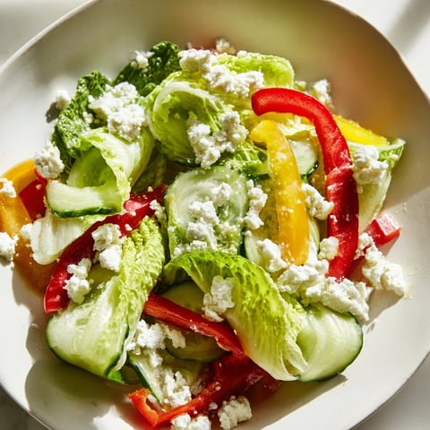 Vibrant Bella Hadid Salad: Crisp lettuce, colorful peppers, and creamy feta, drizzled with zesty lemon dressing.