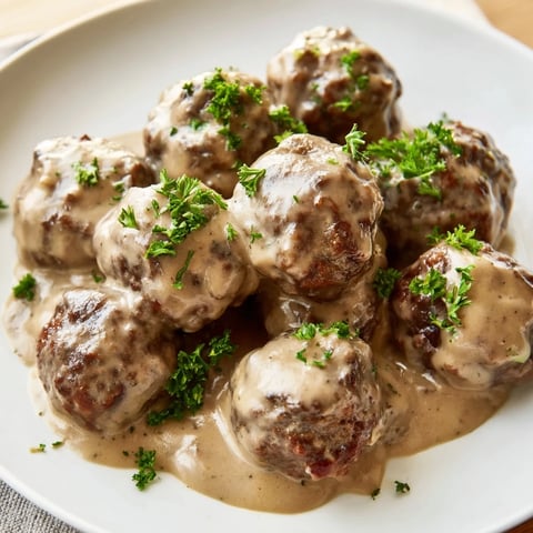 Steaming Swedish Meatballs in a creamy, rich gravy, a classic comfort food dinner.