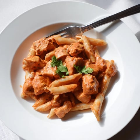 Creamy Chicken Tikka Pasta with charred chicken tikka pieces tossed in a rich, spiced tomato-cream sauce and penne.