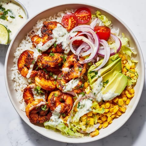 This photo features delicious Cajun shrimp taco bowls, piled high with fresh toppings and a creamy drizzle.