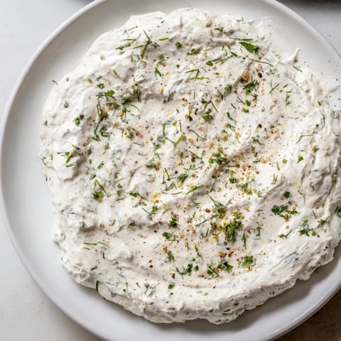 Freshly made Greek Yogurt Ranch Dip, ready to be scooped up with colorful bell peppers.