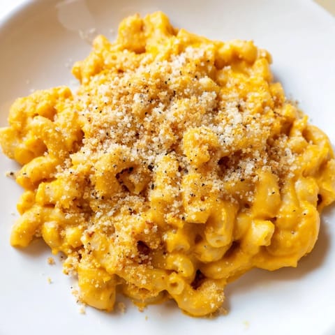 Golden, baked Pumpkin Mac & Cheese bubbling in a dish, offering a taste of autumn comfort food.