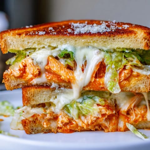 A spicy and savory Buffalo Chicken Caesar Grilled Cheese with crispy bread, creamy Caesar, and tangy buffalo chicken.