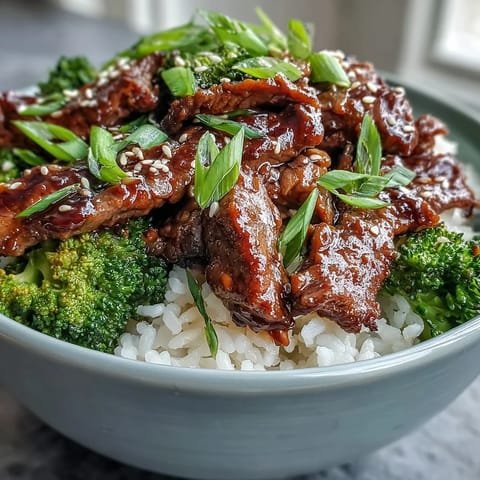 Tender strips of beef in savory soy-ginger sauce over fluffy rice with bright green broccoli florets. 