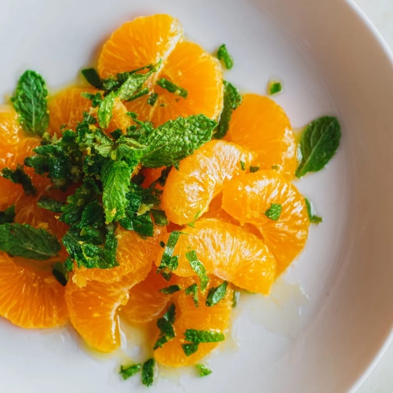 Vibrant clementine and mint winter fruit salad, a sweet and tangy light dessert, ready to serve.