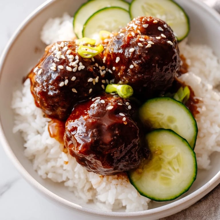 Imagine warm jasmine rice topped with tender teriyaki meatballs and fresh cucumber slices in these bowls.