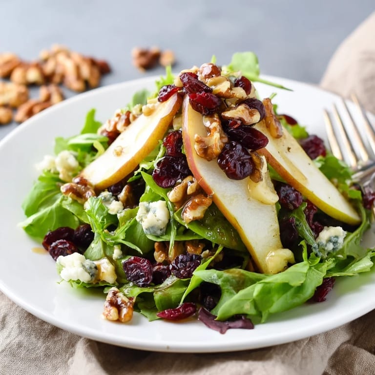 A light and refreshing Pear Gorgonzola Salad served on a rustic wooden table, showcasing juicy pear slices and blue cheese crumbles.