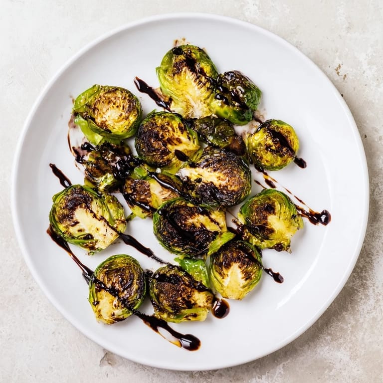 A close-up view of caramelized Brussels sprouts with balsamic reduction, perfect for a holiday side dish.  