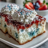Festive Memorial Day red, white, and blue poke cake with vibrant gelatin swirls and whipped topping.  